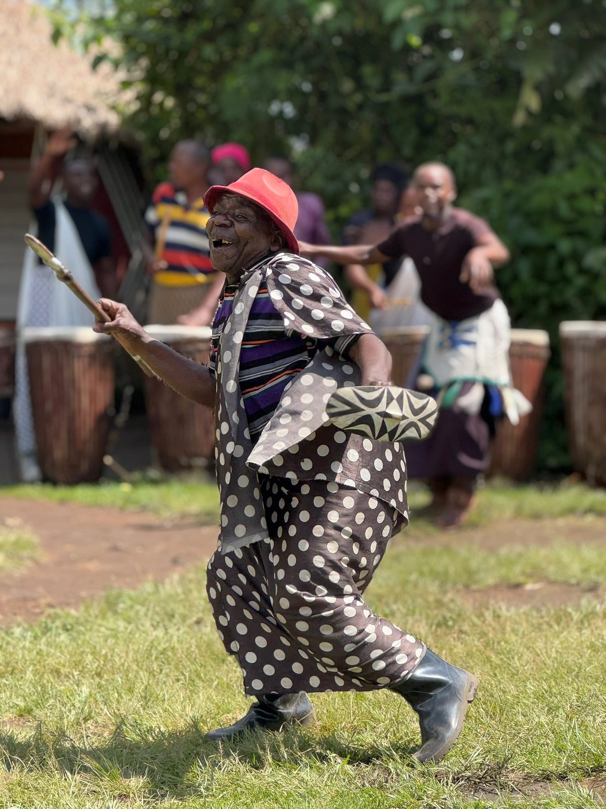 Elder dancing with drummers at a cultural village, Rwanda