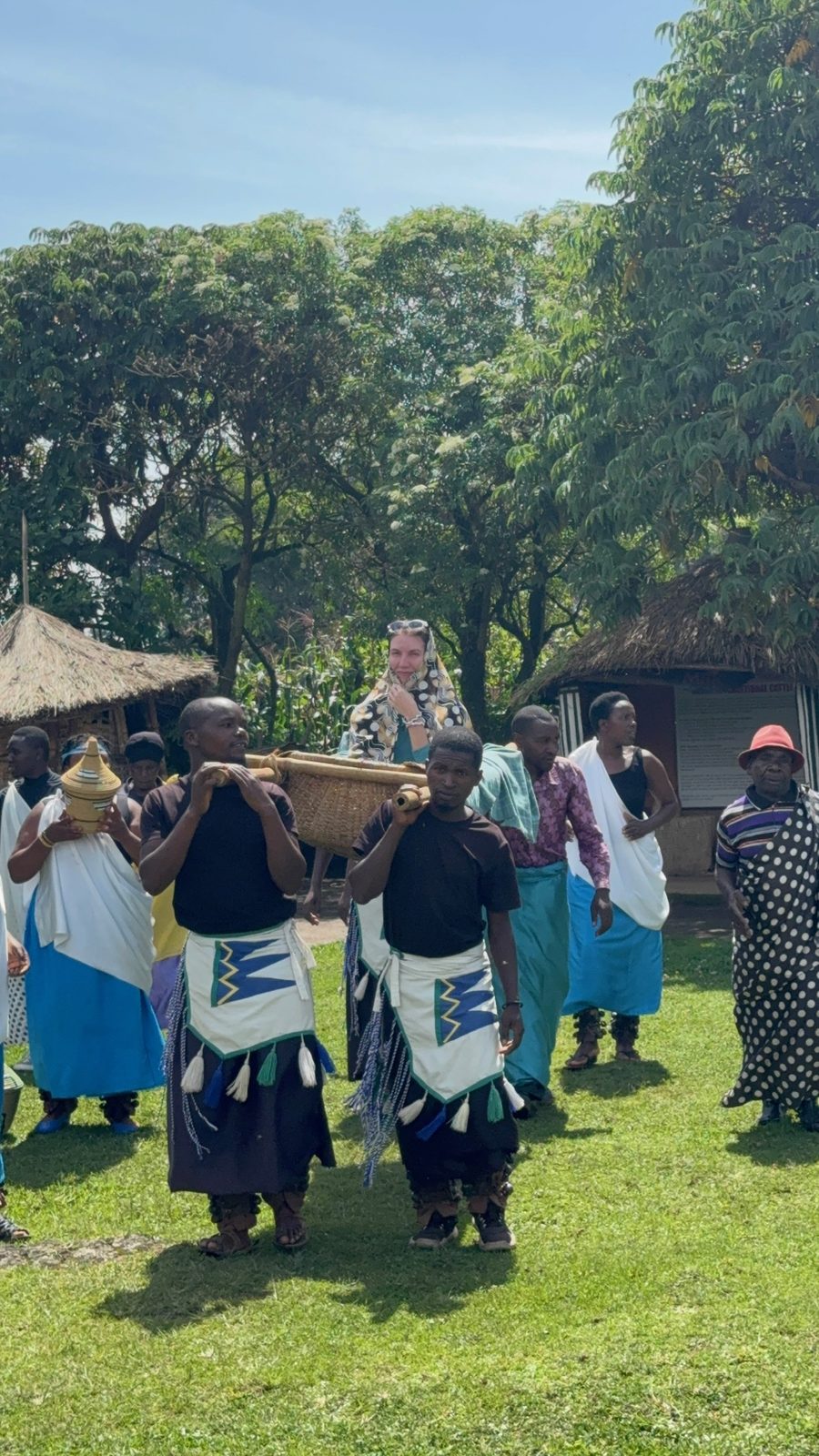 A guest carried in a traditional basket during a cultural village welcome